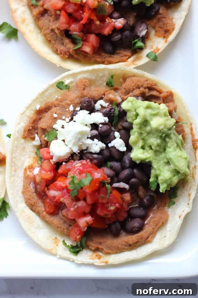 A single tostada topped with a generous scoop of guacamole and fresh cilantro, highlighting a delicious topping option.
