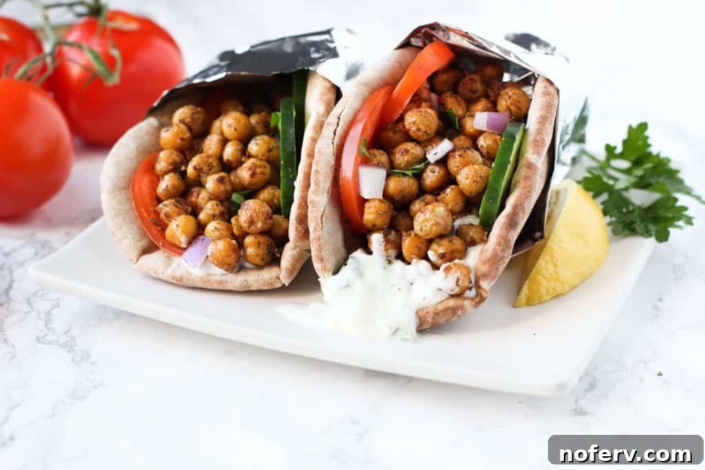 A plate of Chickpea Gyros, beautifully arranged with fresh toppings and a side of tzatziki sauce.