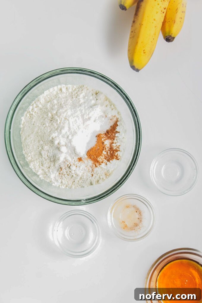 Whisking dry ingredients: flour, baking powder, cinnamon, and salt in a bowl.