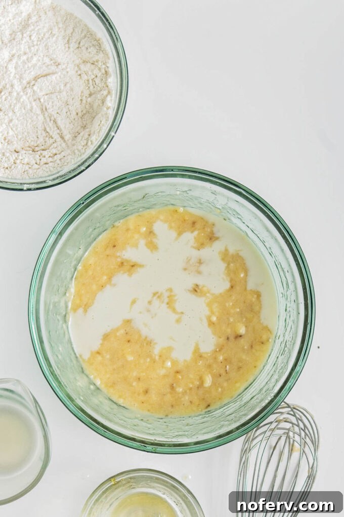 Adding oat milk to the wet ingredients mixture.