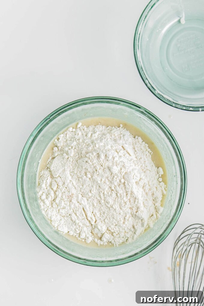 Adding the dry flour mixture to the wet ingredients and stirring until just combined.