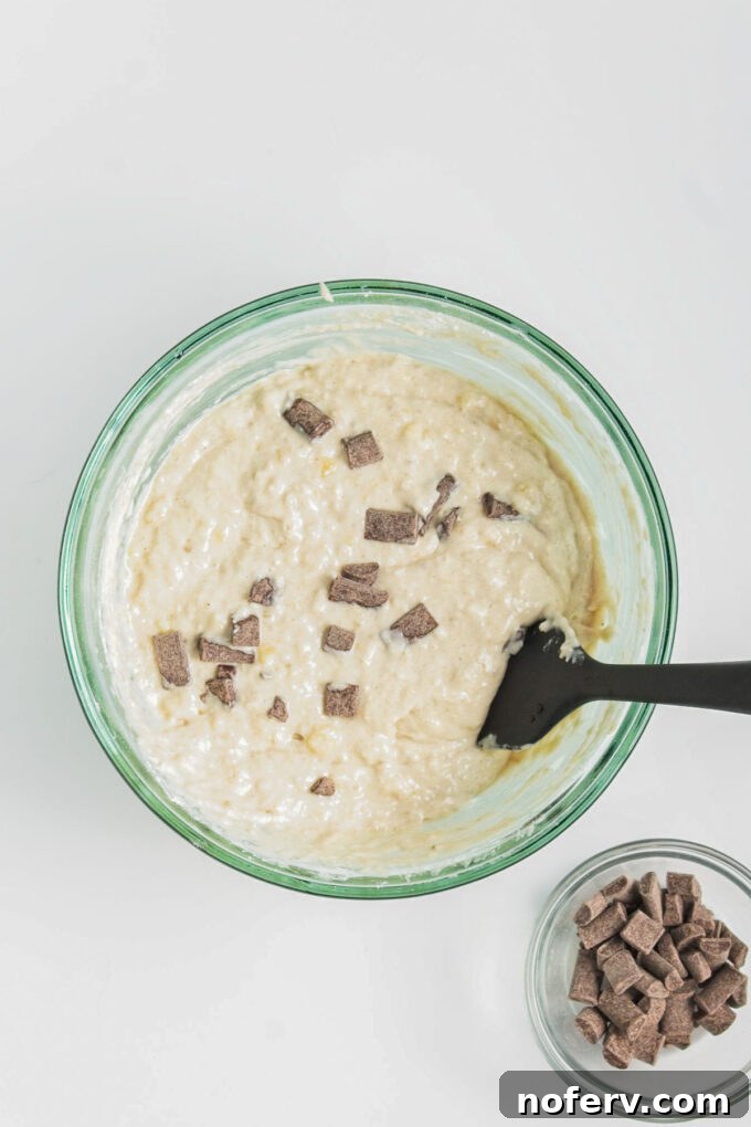 Folding vegan chocolate chips into the pancake batter.