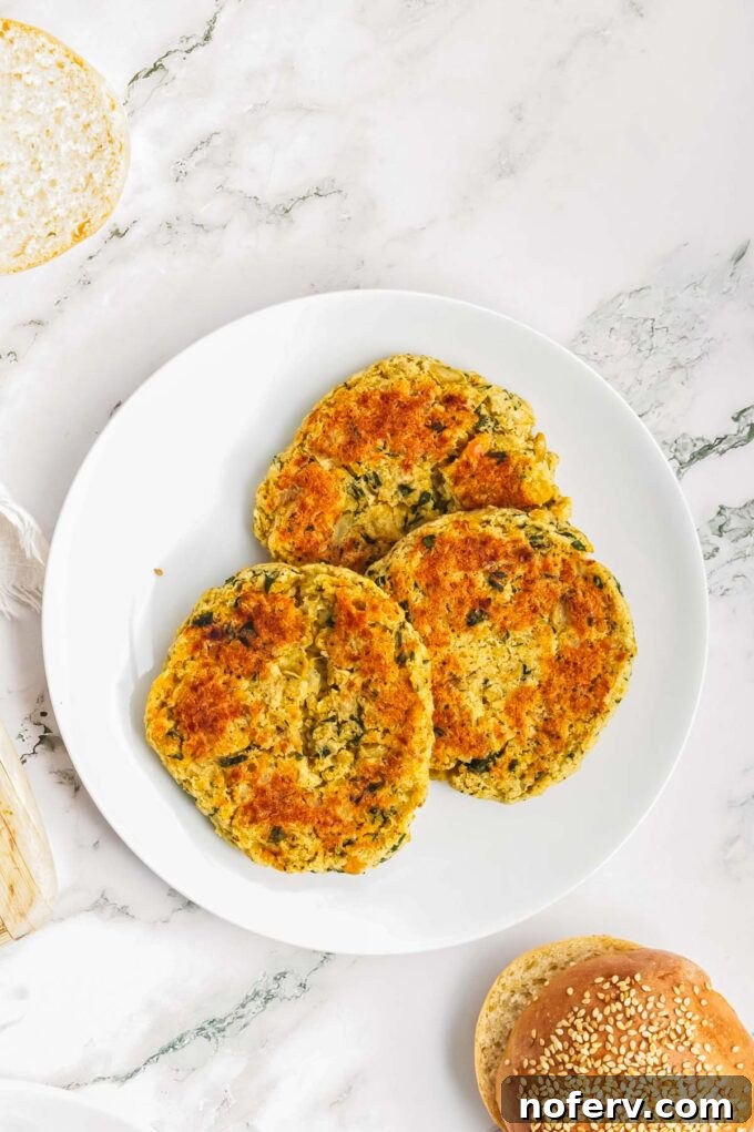 Golden Chickpea Burger Delights 11 Finished chickpea burger served on a bun with avocado and tomato.