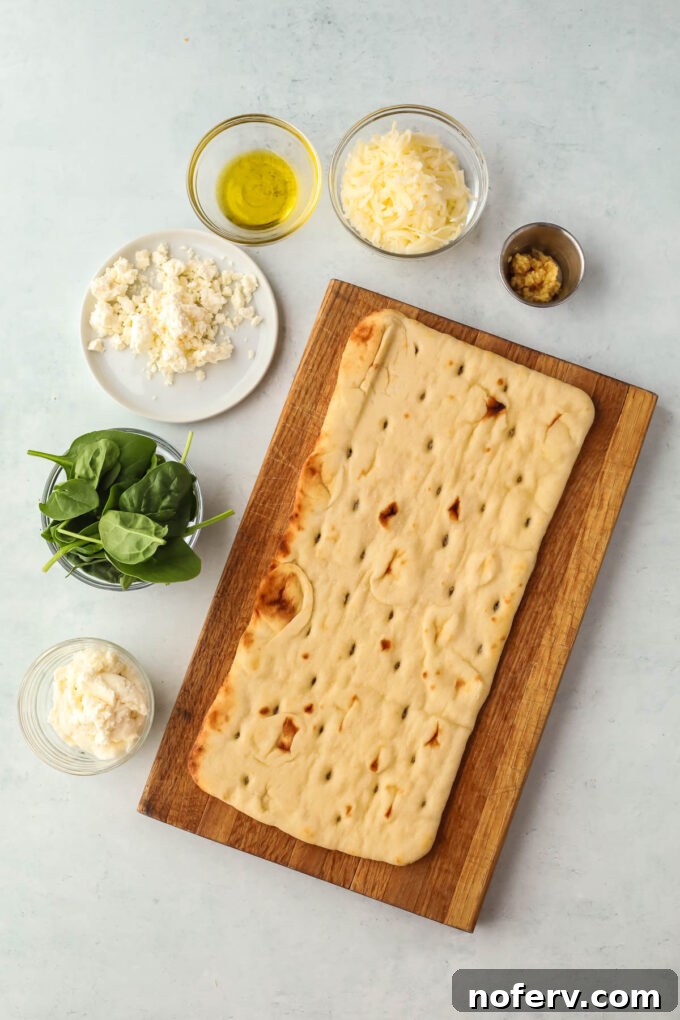 Close-up of freshly baked spinach and feta flatbread with melted cheese