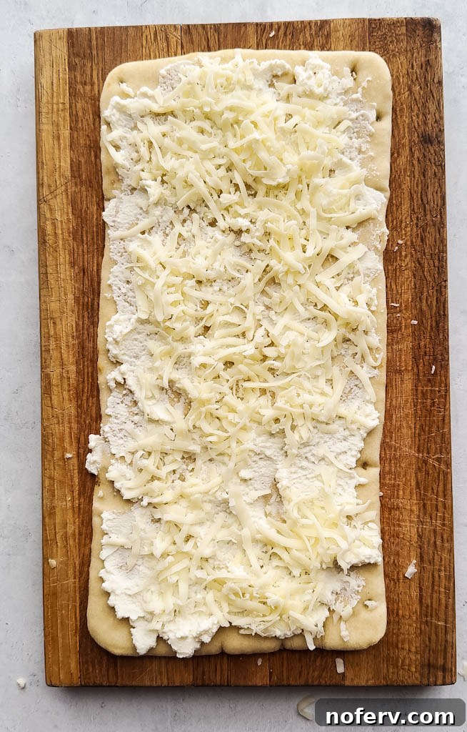 Assembling the flatbread with ricotta, mozzarella, and spinach mixture