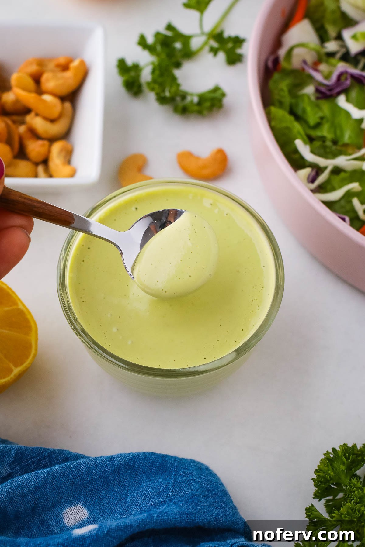 Creamy Vegan Herb Dressing on a spoon, vibrant green and fresh