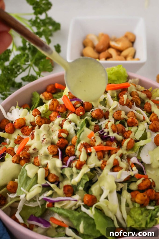 Vegan Herb Dressing drizzled over a fresh green salad in a bowl