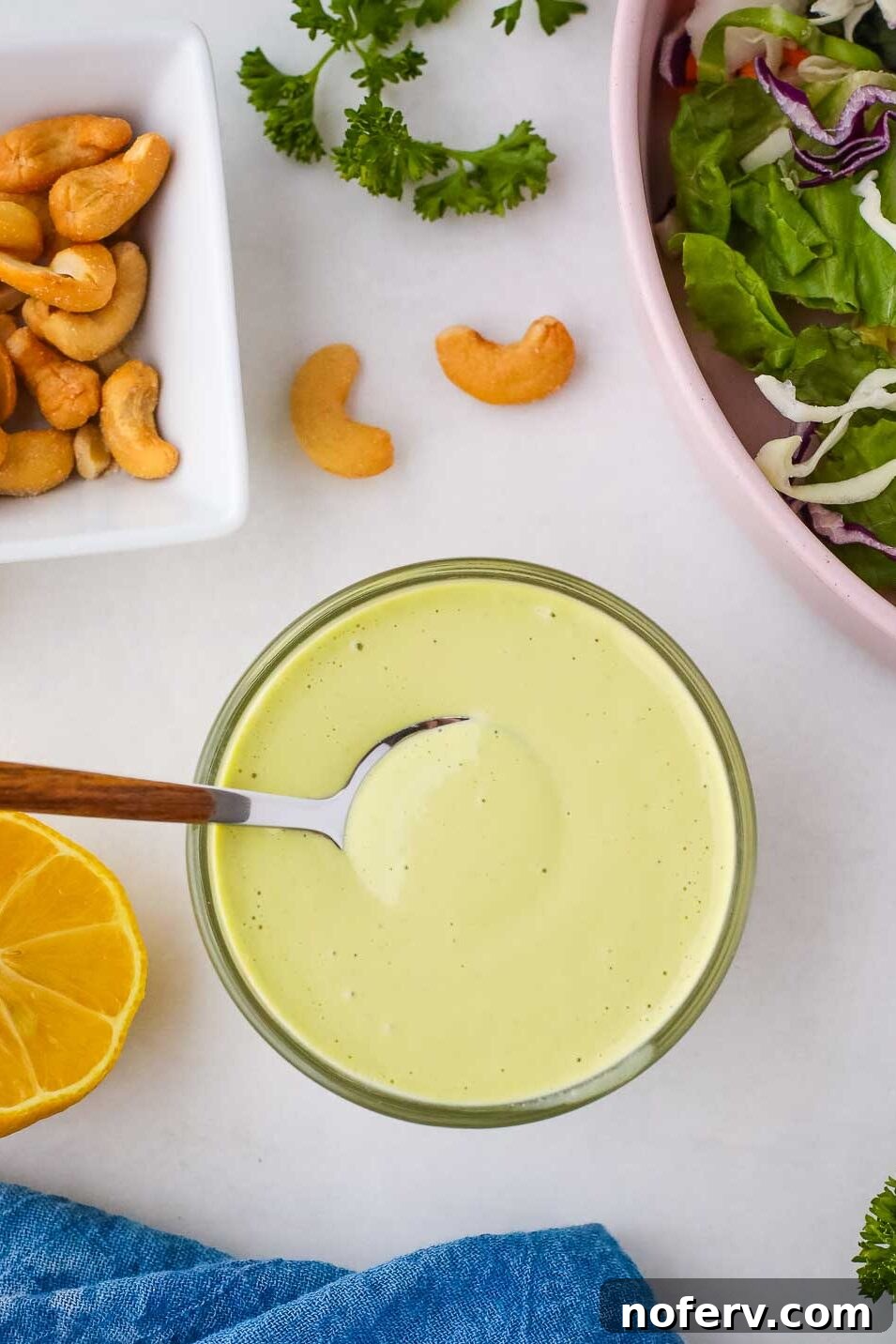 Close-up of a serving of vegan herb dressing in a small white bowl with a spoon