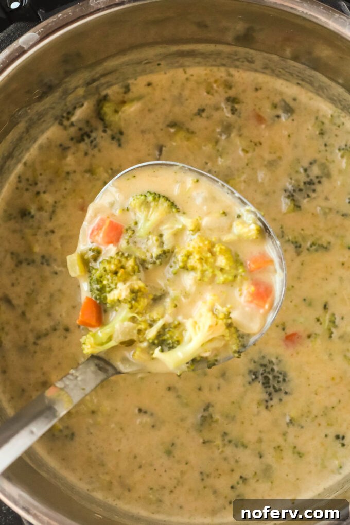 One cup of soup being transferred to a blender, with milk and cottage cheese nearby.
